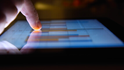 Fototapeta premium Businessman working in night office and using digital tablet