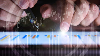 Businessman hand using tablet with stock market report interface.