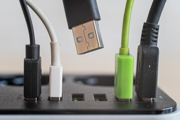 Modern convenient multi-port usb charger for devices. Close-up of inserted multi-colored cables in a power outlet. Macro.