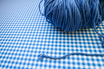 Blue yarn ball on a blue checkered background. 