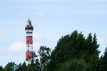 old tall Osinovetskiy lighthouse on a blue sky background on a coast of Ladoga lake