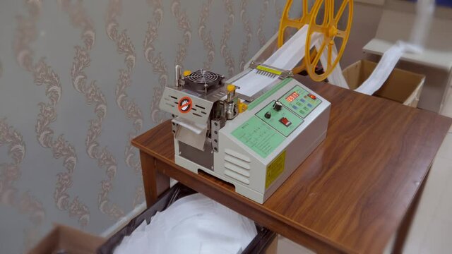 manufacture of corona virus mask. The machine curls the fabric. The cutting process is done. Mask folding, cutting and ironing  4K