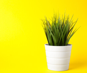 Beautiful artificial plant in flower pot on yellow background, space for text