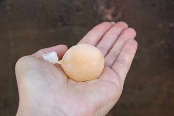 On the woman's hand is a chicken egg without a shell in a film bag. It can be because of the...
