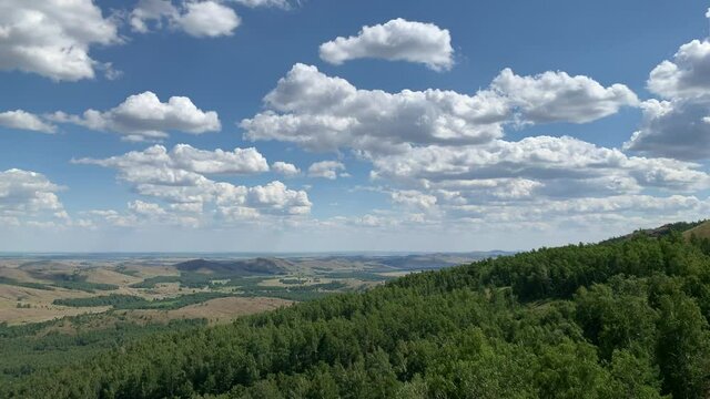 4K video Shooting from the cabin of a moving lift to the mountain. Panoramic view on mountains, lakes and forests Blue sky