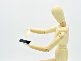 Maniqu&iacute; de madera llamando con un tel&eacute;fono m&oacute;vil