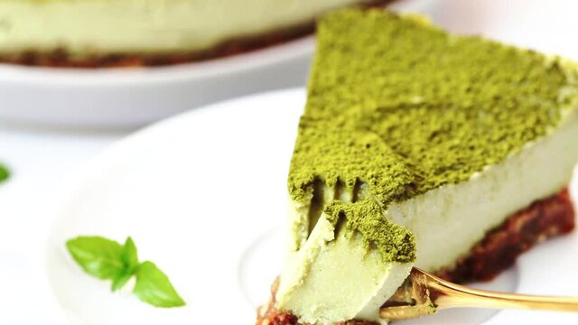 Slice of raw vegan matcha cake on white plate.