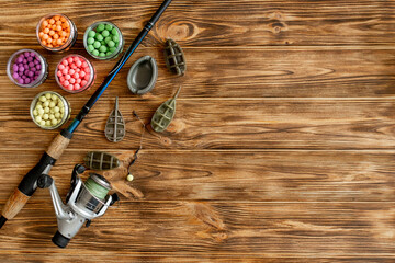 Accessories for carp fishing and fishing baits on wooden planks with copy space