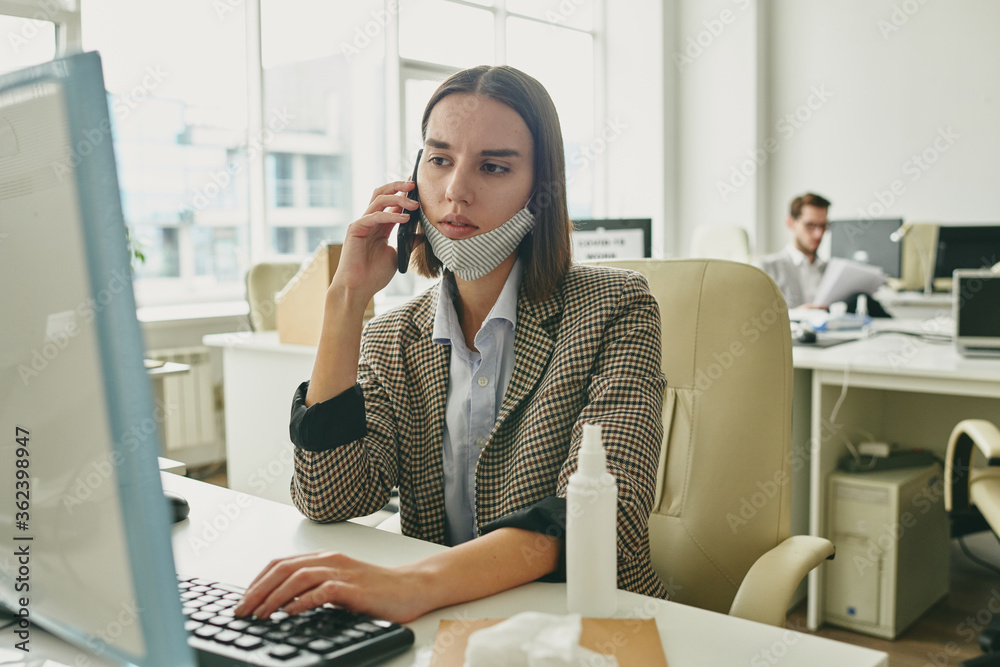 Poster serious businesswoman pushing keyboard key while looking at computer screen