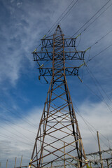 Power pole with wires against the blue sky. Electricity production and transportation