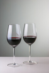 Two glasses of red wine in neutral background