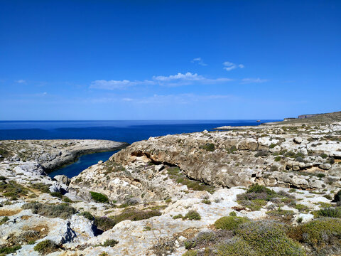 The view on the rocky landscape with a sea bay between Cala Greca and Cala Galera filled with clear blue Mediterranean water. Background landscape.