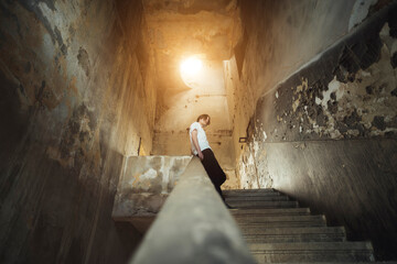 Modern young man on stairs in ruins