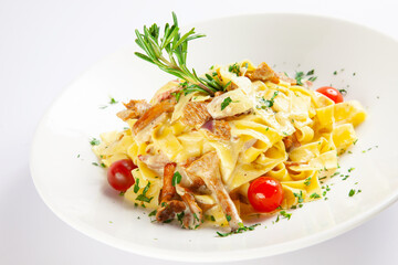 Italian tradidtional fettuccine pasta with mushrooms, rosemary herb, and tomatoes on white plate, isolated on white background.  Restaurant menu shot