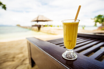 Mango juice on in front of the tropical sea