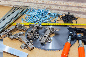 Screws, confirmations for furniture, tape measure, lie on the table. Furniture production