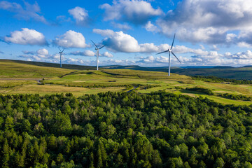 Aerial drone shot of several clean energy wind turbines in a rural area of South Wales, UK