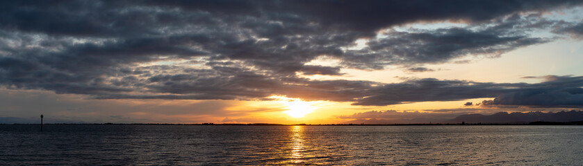Obraz premium White Rock, Greater Vancouver, British Columbia, Canada. Beautiful Panoramic View of a cloudy and colorful sunset over the Pacific Ocean Coast. Nature Background Panorama