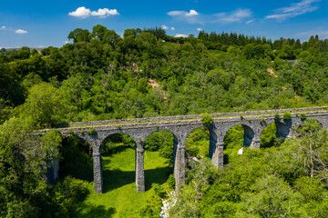 Fototapeta na wymiar Aerial view of an old Victoria viaduct in a green valley on a beautiful summers day (Pontsarn Viaduct)