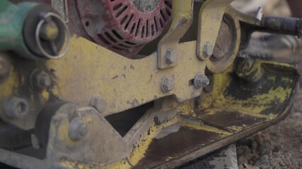 Vibratory asphalt paving machine on the sidewalk filmed close-up.Road works,pavement repair,hard work.Video clip