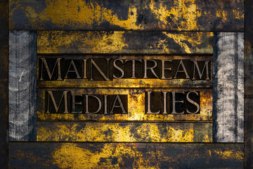 Mainstream Media Lies text formed with real authentic typeset letters on vintage textured silver grunge copper and gold background