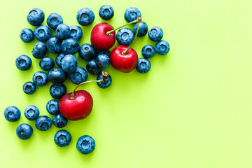 Many fresh blueberries on green-yellow background