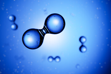 3d render: Abstract hydrogen molecules H2 in front of blue vignetted background. Alternative Energy...