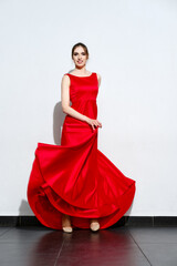 Portrait of girl in waiving red silk dress