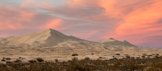Incredible scenic desert landscape featuring giant sand dunes and a colorful sunset. Photographed at Kelso Dunes in Mojave Desert National Preserve