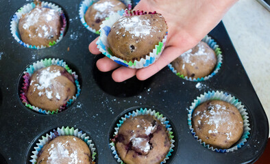 hand that grabs a muffin in muffin mold