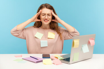Tired fatigued overworked woman employee in glasses covered with sticky notes, clasping head,...