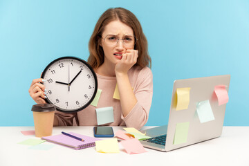 Upset nervous woman employee sitting at workplace office, all covered with sticky notes and holding...