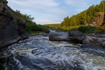 Ural Mountains. Rocks and rocky rifts on mountain river in summer. View on valley and the river Iset with rocky banks.