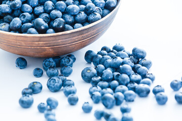Freshly picked blueberries in wooden bowl. fresh blueberries on a white rustic table. selective focus.