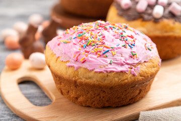 Homemade glazed and decorated easter pies on a gray wooden background and linen textile. Side view, selective focus.