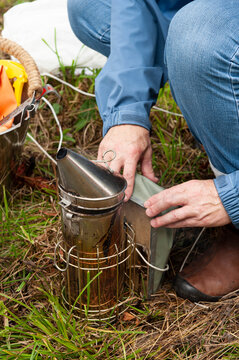 Beekeeper preparing a bee smoker