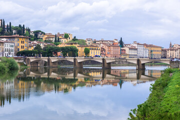 Fototapeta na wymiar Florence or Firenze, Ponte delle Grazie bridge, landmark on Arno river, landscape with reflections on the water. Tuscany, Italy. 