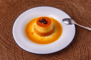 Homemade milk pudding with caramel cream. Traditional Brazilian dessert on a plate on wooden...