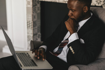 Black Businessman using laptop for analyzing data stock market, forex trading graph, stock exchange...