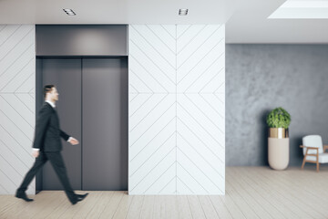 Businessman walking in office hall with elevator
