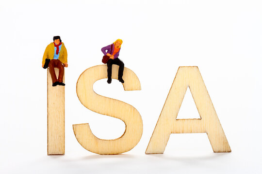 Miniature Figure Couple Sat On Wooden ISA Letters Individual Tax Free Savings Account Concept