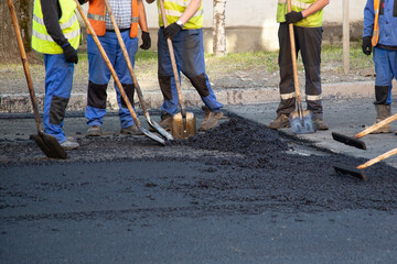 Asphalting and road repairs. The team of construction workers repairing roads.