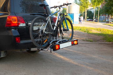 A passenger car carries a Bicycle on a special device.