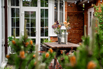 table in garden of country house. candlesticks and bouquet of flowers.