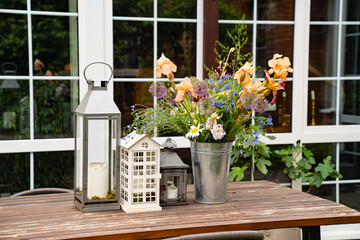 table in garden of country house. candlesticks and bouquet of flowers.