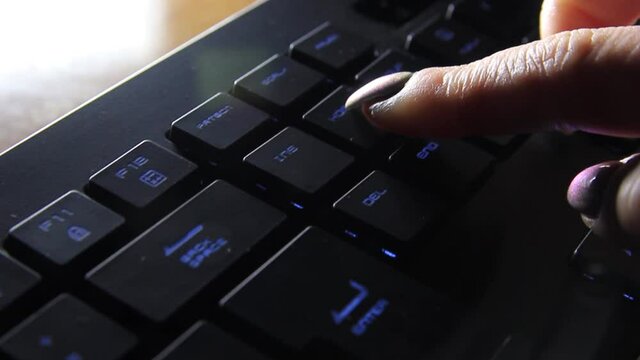 the female finger presses a button on the keyboard and it changes colors.