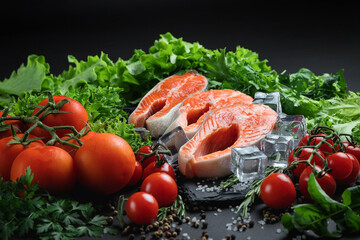 Red fish on a stone plate. Still life with seafood and vegetables. Seafood on a dark background. Sea fish. Red caviar.