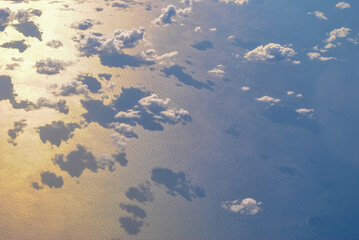Photo taken from above above many clouds. Under the clouds is the sea.