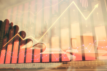 Double exposure of financial chart drawing and desktop with coffee and items on table background. Concept of forex market trading