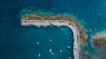Aerial top view of antique harbor with wooden boats in Paul do Mar, Madeira island, Portugal